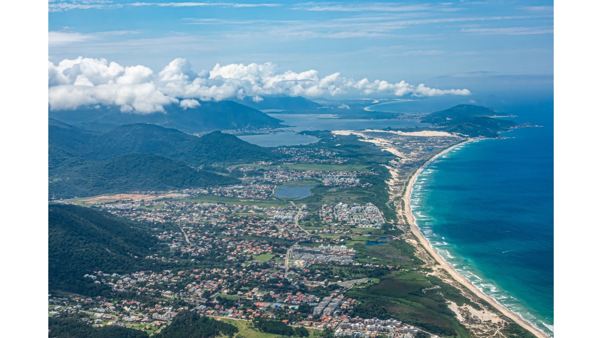 Vista aérea del Campeche con playa extensa, lagunas y cerros verdes al fondo