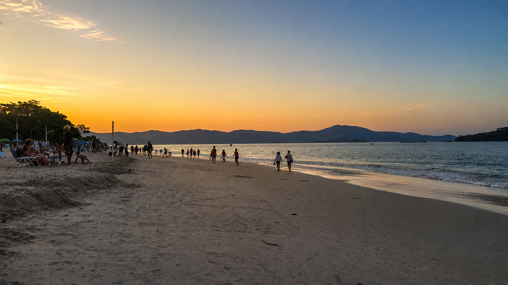Playa de Canasvieiras al atardecer con personas caminando y morros al fondo
