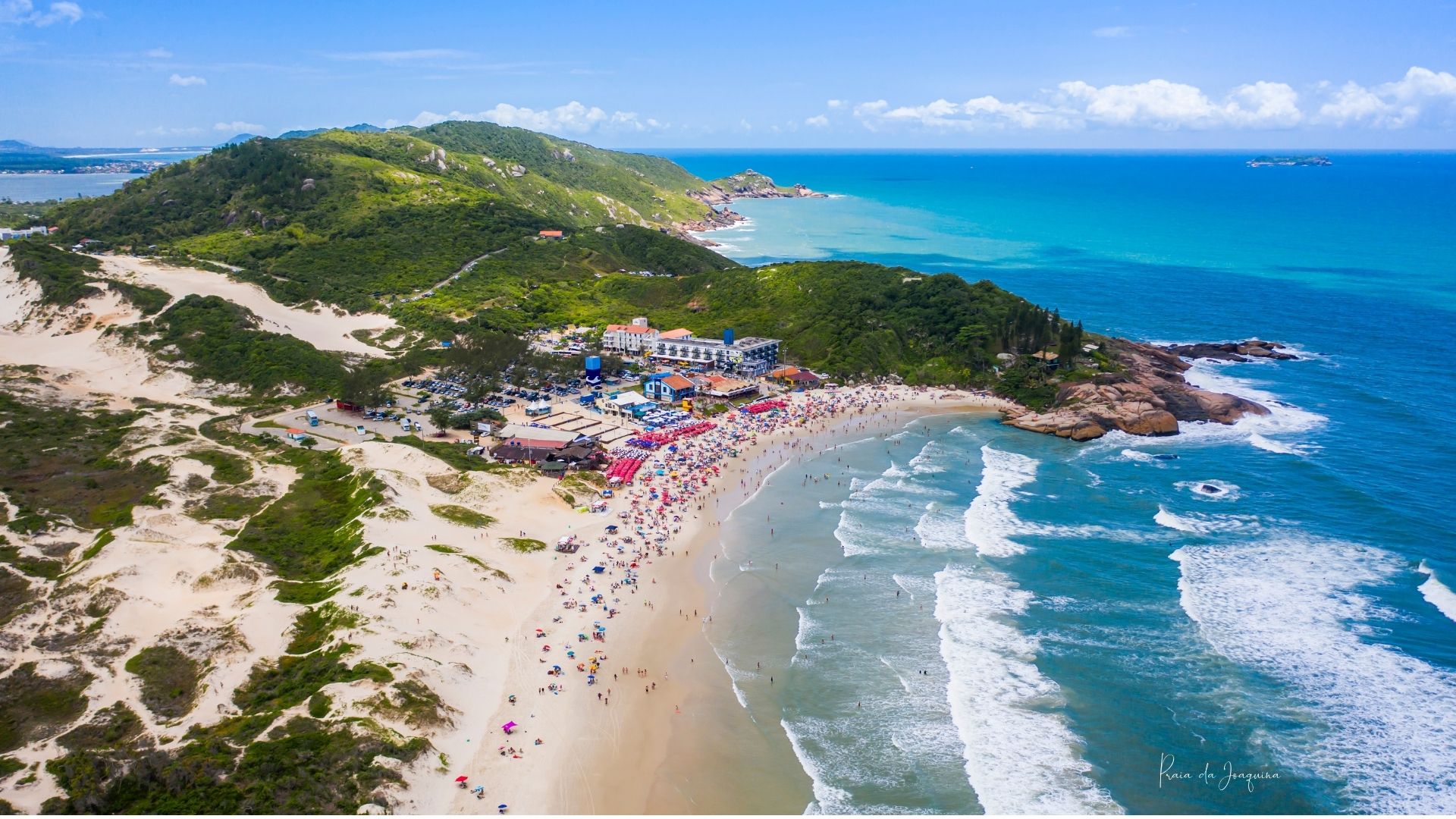 Vista aérea de la Praia da Joaquina con dunas, morro verde y mar turquesa