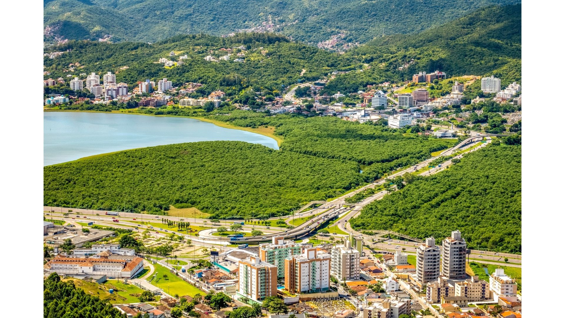 Vista aérea de Florianópolis con vías estructurantes, manglar preservado y edificios de baja altura
