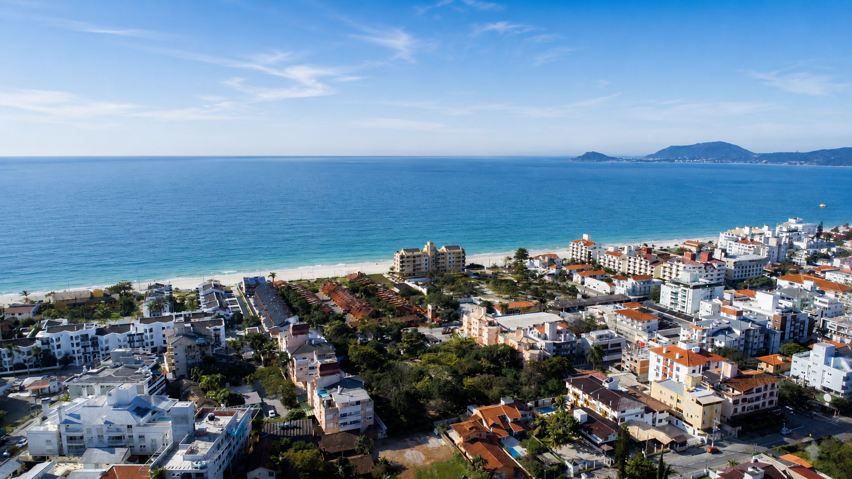 Vista aérea de Canasvieiras con la playa, el mar turquesa y el barrio residencial
